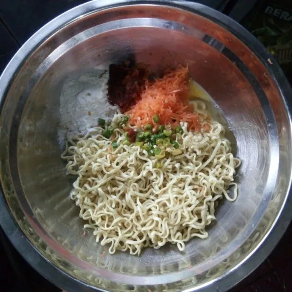Dalam wadah, campur mie, telur, tepung terigu, bumbu halus dan cabai rawit potong.