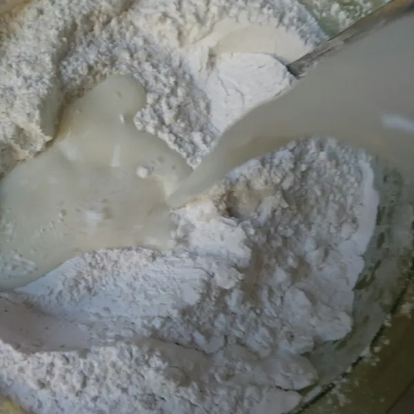 Tuangi tepung dengan santan perlahan. Aduk sampai tidak ada yang bergerindil. Saring.