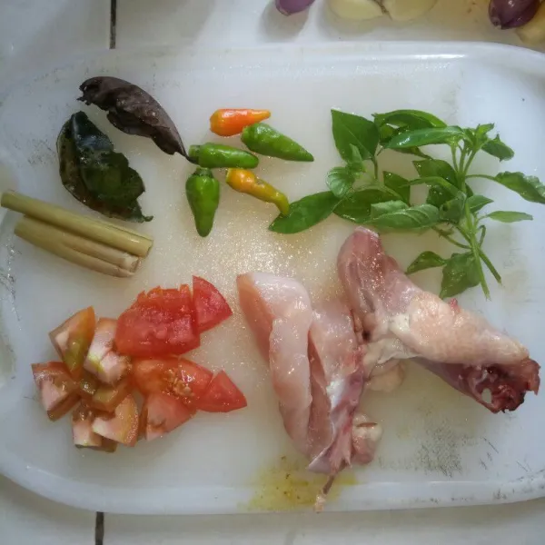 Cuci bersih ayam, tomat, cabe rawit, kemangi, daun salam, daun jeruk dan serai. Potong-potong sesuai selera.