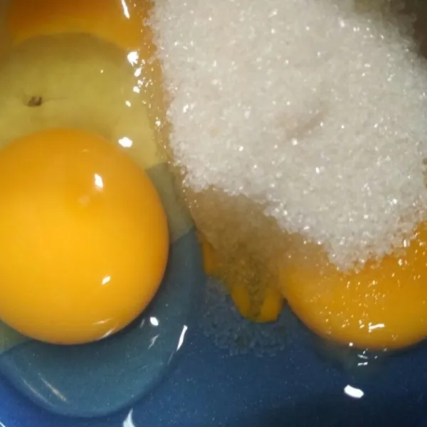 Dalam mangkuk pecahkan telur tambahkan gula pasir kocok lepas dengan whisker hingga gula larut.
