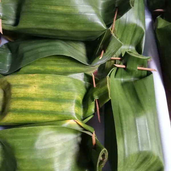 Bungkus dengan daun pisang dan sematkan lidi agar terbungkus rapi. Lakukan berulang hingga semua bahan habis.