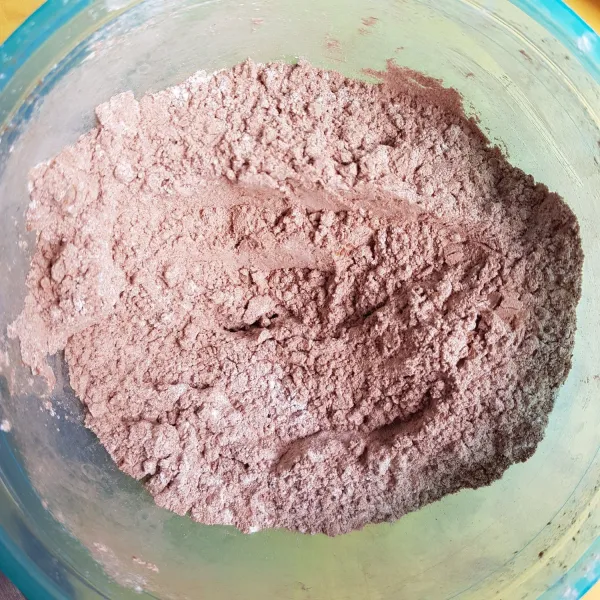 Siapkan wadah, kemudian masukkan sambil diayak tepung beras, coklat bubuk, gula halus dan baking powder. Aduk hingga rata.