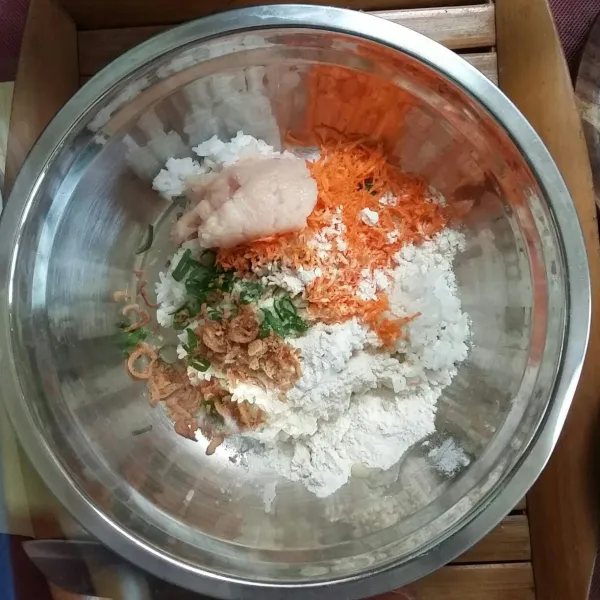 Dalam wadah campur nasi dengan tepung bumbu, ayam cincang, wortel serut, daun bawang, dan bawang goreng. Aduk rata, beri secukupnya garam dan lada. Aduk rata.