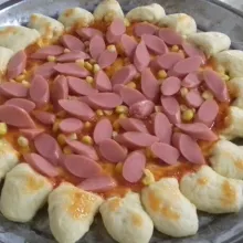 Tusuk-tusuk bagian tengah dengan garpu, beri saus bolognese, saus sambal, pipilan jagung manis dan irisan sosis.