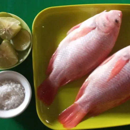 Bersihkan ikan nila dan beri garam serta air jeruk nipis.