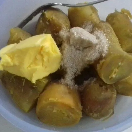 Kupas ubi panas-panas, masukkan gula dan margarin, hancurkan dengan garpu hingga gula dan margarin larut.