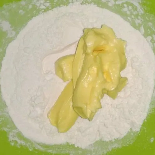 Membuat kulit pie, siapkan tepung dan margarin, tambahkan 2 sdm susu kental manis. Aduk dan uleni sampai kalis.