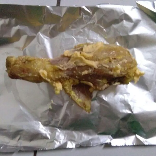Siapkan alumunium foil, lalu oles ayam dengan margarin dan letakkan ayam di atas alumunium foil.