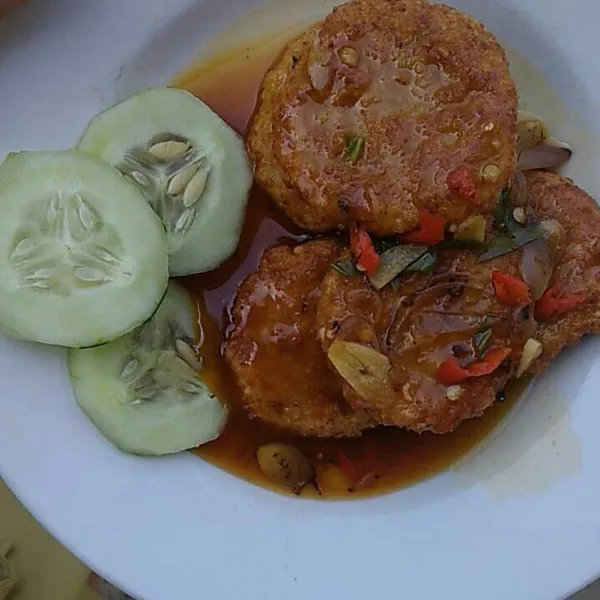 Sajikan steak tempe dengan siraman saus dan irisan timun.