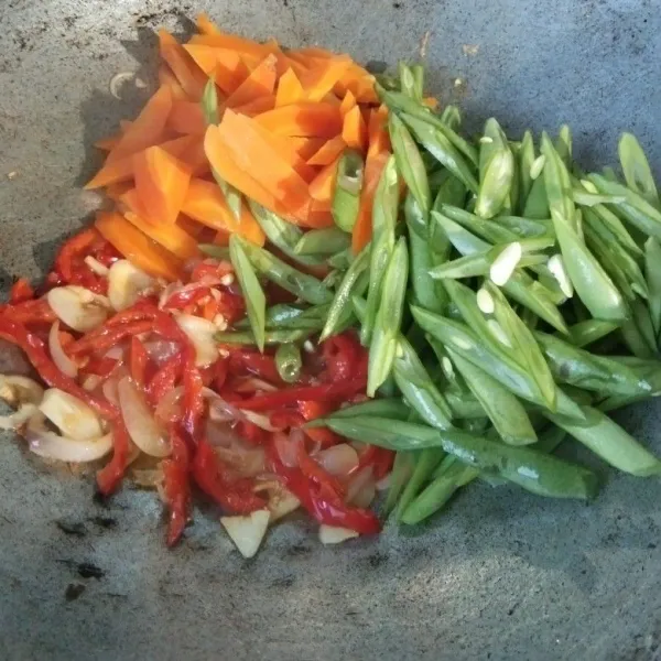 Masukkan sayuran, aduk rata beri sedikit air saja untuk melunakan buncis dan mematangkan wortel.