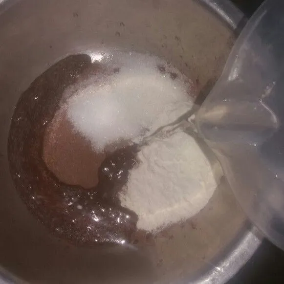 Campur chocolatos drink, tepung terigu, dan gula pasir dalam satu wadah, lalu tuang 100 ml air panas. Aduk hingga tercampur rata dan gulanya larut.