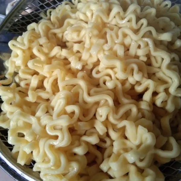 Rebus mie hingga setengah matang, angkat dan tiriskan, beri 1 sendok makan minyak goreng, aduk supaya mie tidak lengket dan menempel satu sama lain.