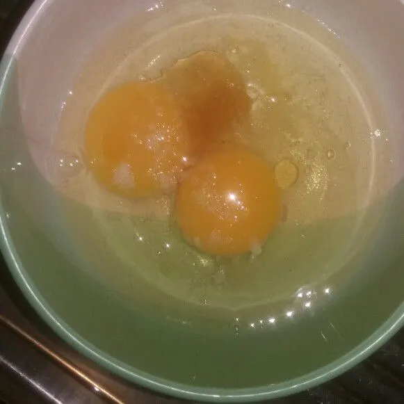 Pecahkan 2 butir telur, bumbui dengan garam, gula, kaldu bubuk dan minyak wijen lalu kocok hingga berbuih.