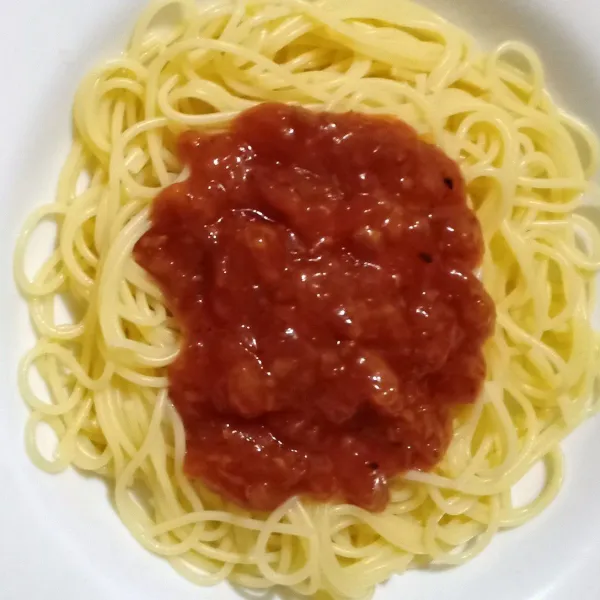 Tata di piring,tuang saus bolognese di atas spaghetti..