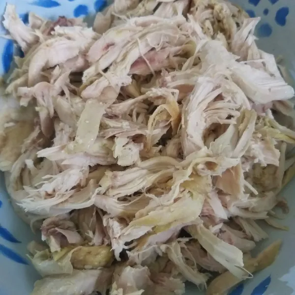 Dada ayam direbus, dinginkan dan disuwir-suwir.