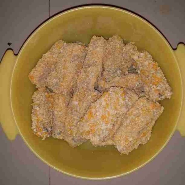 Campurkan tepung terigu dan air. Aduk hingga tidak bergerindil. Celupkan nugget ubi ungu ke dalam adonan tepung kemudian gulingkan ke dalam tepung roti.