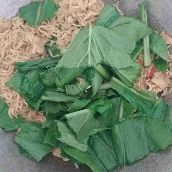 Tambahkan sawi, aduk-aduk sampai sawi layu.