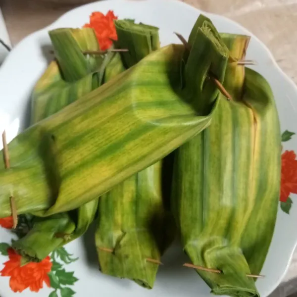 Bungkus dengan daun pisang dan sematkan lidi agar terbungkus dengan rapi. Lakukan berulang hingga semua bahan habis.