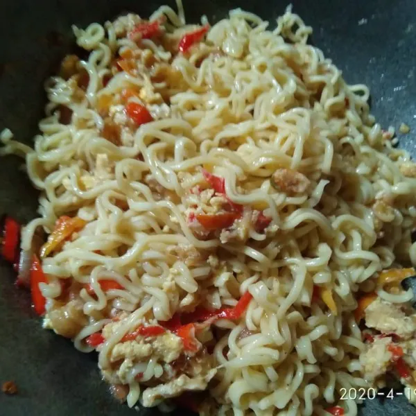 Masukkan mie dan bumbu-bumbu ke dalam wajan, beri sedikit air agar tidak gosong dan bumbu tercampur rata.