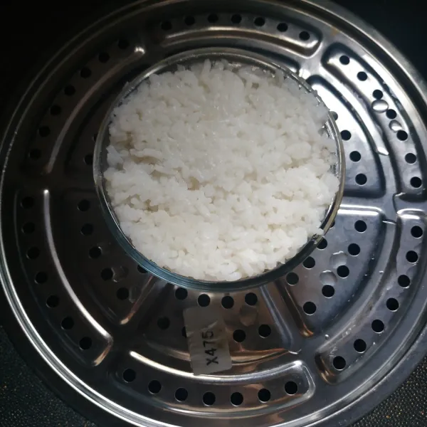 Tuang nasi, padatkan kemudian kukus 15 menit, keluarkan nasi dari mangkok, sajikan.