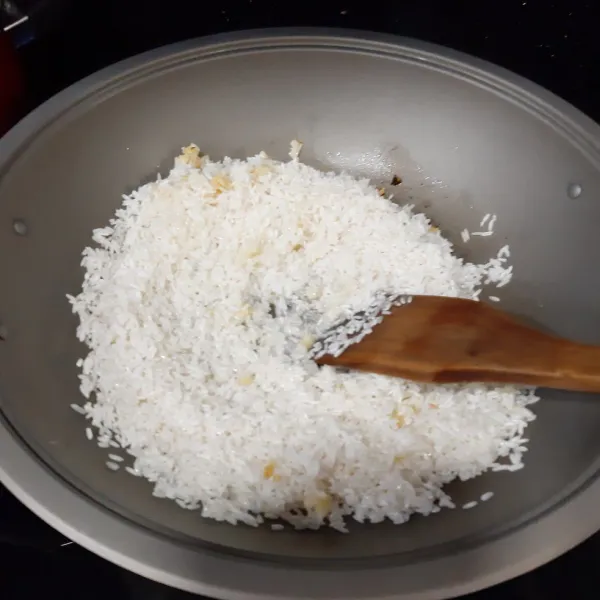 Tumis sisa bawang putih hingga harum lalu masukkan beras.