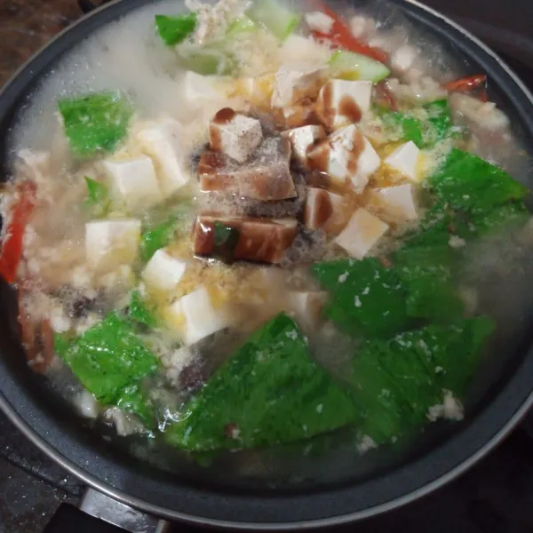 Masukkan sedikit air, tahu, pokcoy, dan jamur. Masak sampai sayuran empuk. Kemudian masukkan garam, kaldu totole, saus tiram, minyak wijen dan kecap asin. Aduk rata