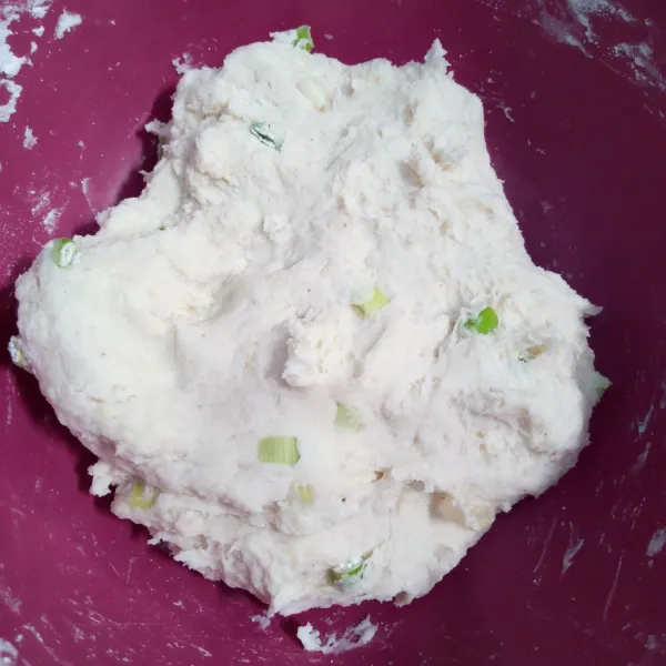 Kemudian tuang kedalam campuran tepung terigu, tepung tapioka dan daun bawang. Aduk rata. Uleni sampai kalis