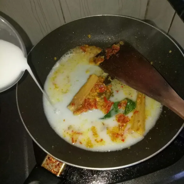 Siapkan pan, tumis bumbu halus sampai harum, masukkan daun jeruk, daun kunyit, serai, kayu manis bubuk. Aduk rata sampai bau langu hilang. Kemudian masukkan santan