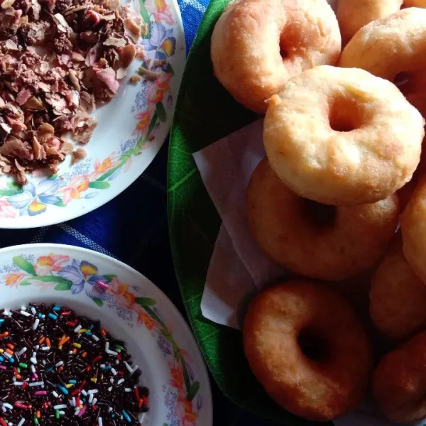 Olesi donat dengan mentega kemudian beri topping.