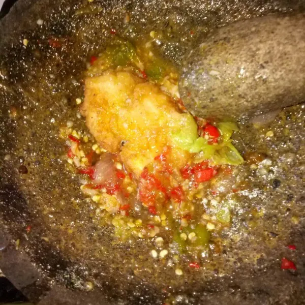 Setelah halus dan tercampur rata siram dengan minyak panas. Aduk rata, geprek ayam sampai setengah hancur. Sajikan dengan nasi hangat