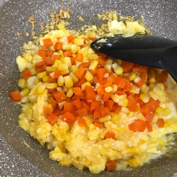 setelah merata, masukan wortel dan jagung yang sebelum nya sudah di rebus. aduk merata.