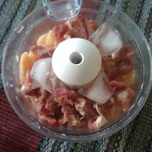 Masukkan potongan daging sapi dan daging ayam serta es batu kedalam chopper. Haluskan.