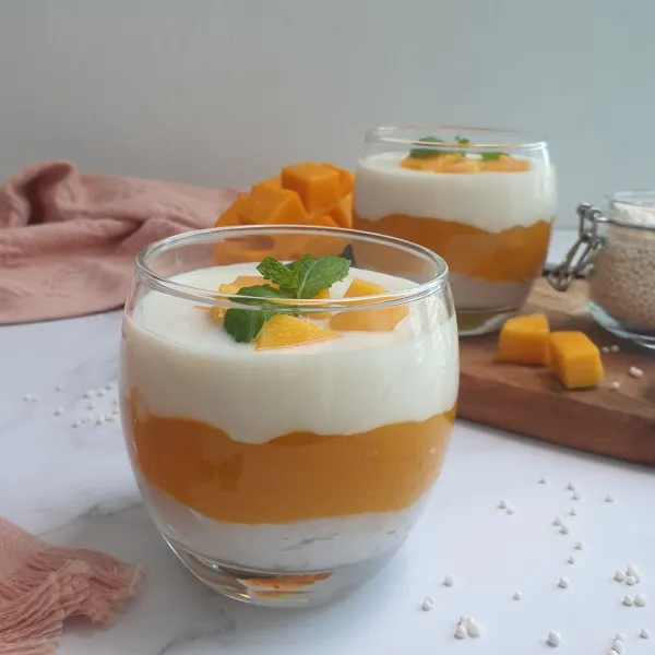 Tuangkan lapisan santan ke dalam gelas berisi puree mangga, taruh potongan mangga di atasnya. Simpan dalam lemari es sebelum disajikan.