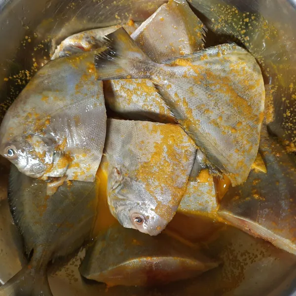 Haluskan kunyit bersama garam kemudian campurkan ke dalam ikan yang sudah diberi jeruk nipis