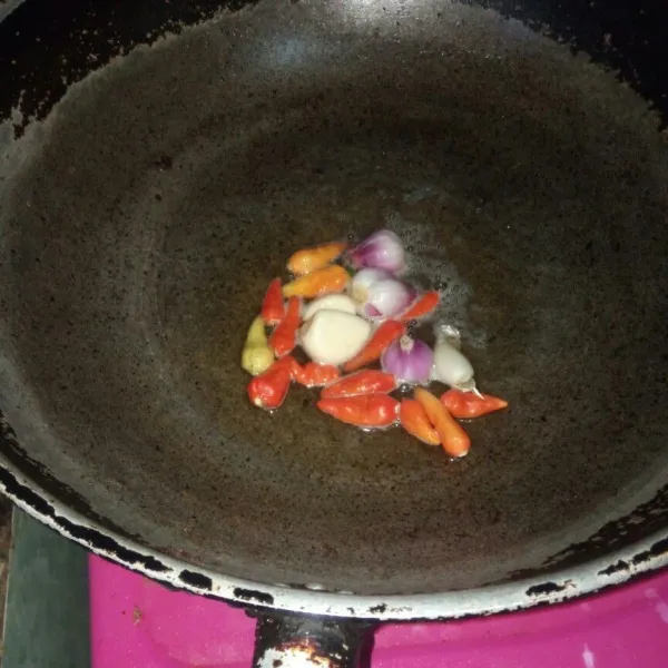 Goreng cabe rawit merah, bawang putih dan bawang merah hingga layu