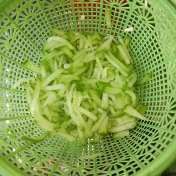 Labu siam dipotong korek api, beri garam lalu remas-remas kemudian cuci bersih, tiriskan