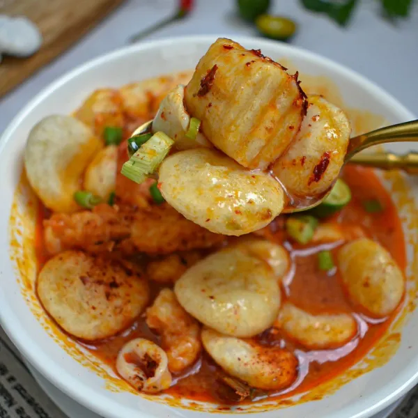 Masukkan cireng ke dalam mangkok, siram dengan kuah seafood, taburkan bawang daun, cabe bubuk, dan peraskan jeruk limau
