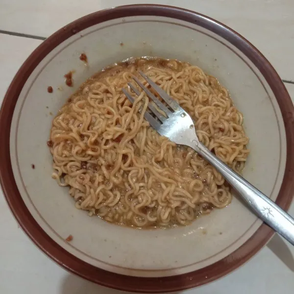 Rebus mi instan tiriskan lalu bumbui, masukkan telur aduk rata