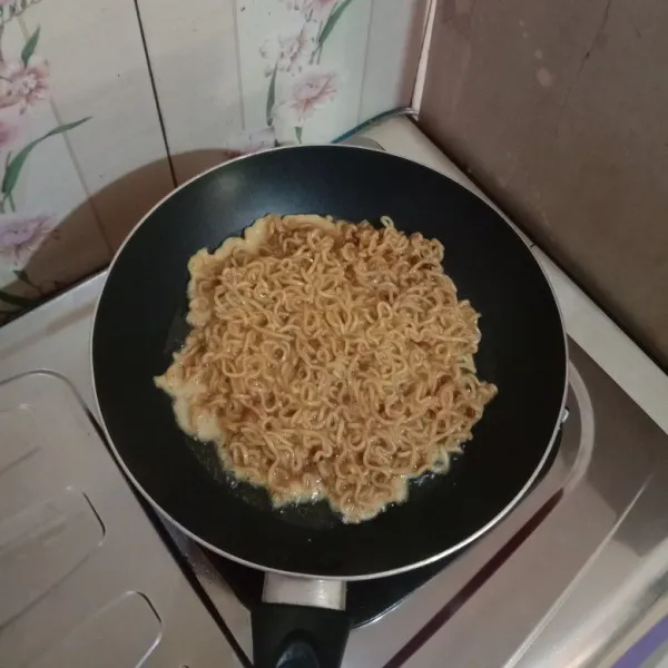 Panaskan teflon, goreng mi hingga bagian bawah kecoklatan kemudian balik masak hingga matang, tiriskan