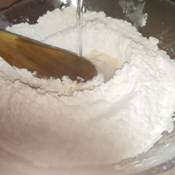 Tuangkan air mendidih secara bertahap, sambil diaduk hingga kalis