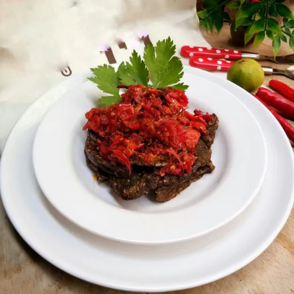 Tata paru goreng dalam piring saji. Beri bumbu balado di atasnya dan siap disajikan