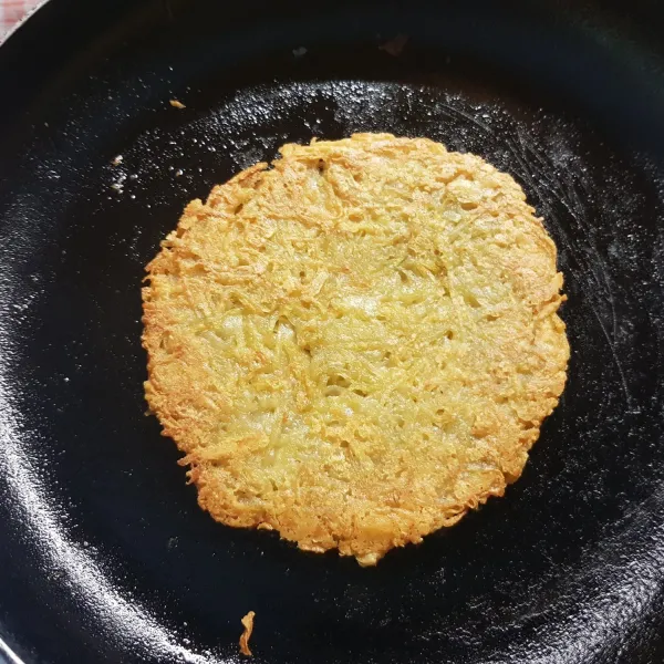 Pan frie kentang dan keju yang dibentuk seperti pancake dengan mentega hingga warnanya keemasan.