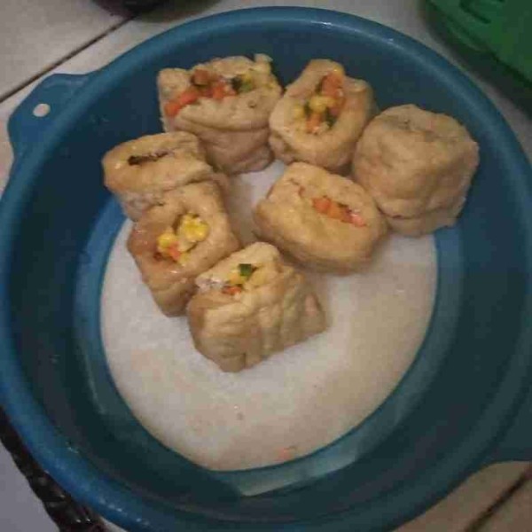 Belah bagian tengah tahu, lalu masukkan tumisan sayur. Padatkan.