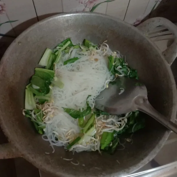 Masukkan sawi, tauge dan daun bawang, aduk rata dengan cepat, bisa diberi sedikit air agar tidak kering