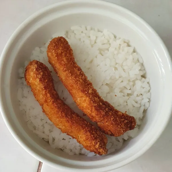 Masukkan nasi ke dalam mangkok tahan panas, susun nugget stick