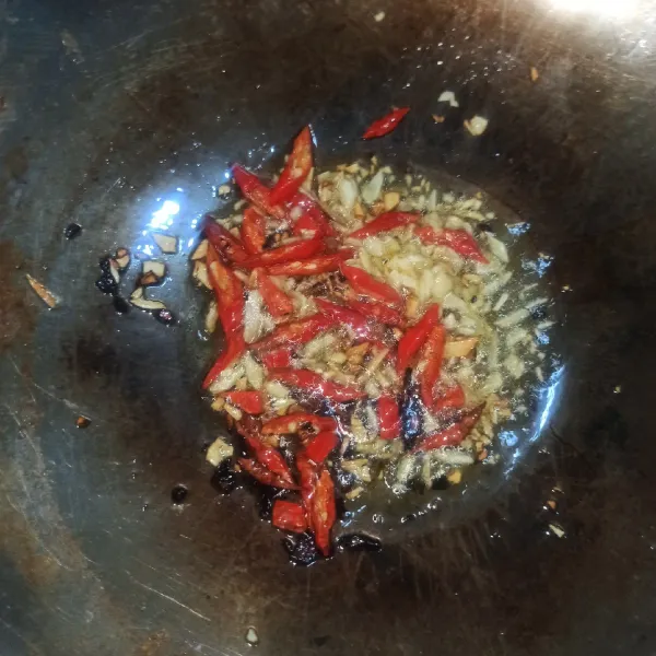 Setelah minyak panas, masukkan bawang putih & cabai merah. Masak hingga mengeluarkan bau harum dari bawang putih
