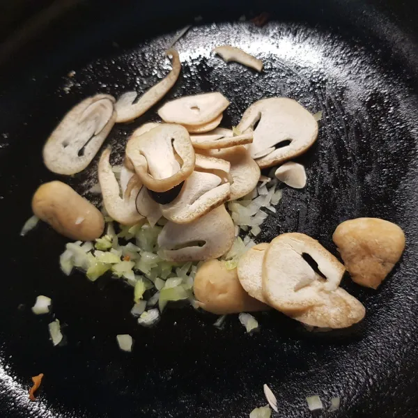 Potong bawang dan jamur, kemudian sauté dengan garam, lada, dan mentega.