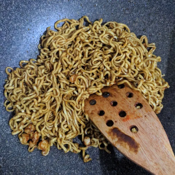 Masukkan mie telur yang sudah direbus sebelumnya. Aduk rata. Masukkan air sedikit agar mie tidak kering. Angkat. Untuk penyajian, taburkan wijen di atas ramen goreng