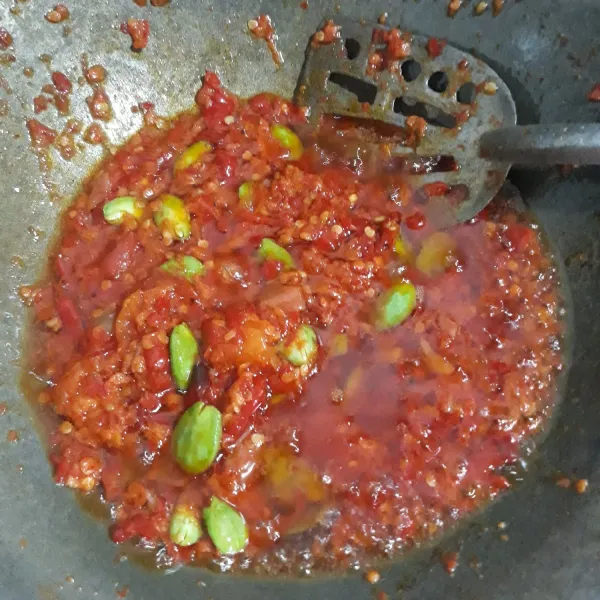 Lalu masak cabe, masukkan tomat, petai, garam, kaldu bubuk  aduk-aduk sampai bau langgu hilang, matikan api campurkan teri dan telur