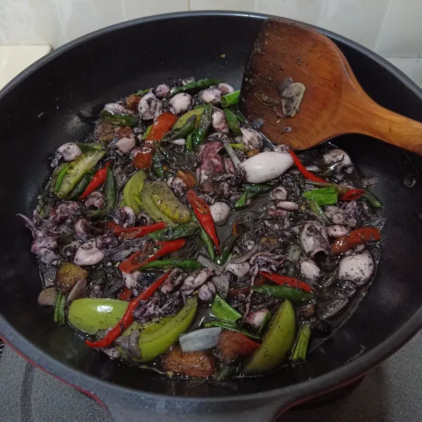 Setelah mendidih dan cumi empuk, buka tutup wajan, koreksi rasa. Terakhir masukkan tomat dan daun bawang, aduk rata, masak sebentar, kemudian matikan api dan sajikan.
